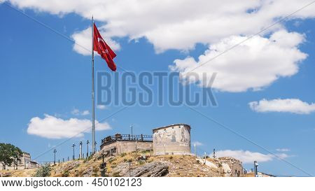 Castle In The City Of Potters Avanis With The Turkish Flag Against The Blue Sky, Turkey.