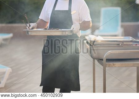 Close-up Of Chef Carry Cooked Meal, Metal Construction For Frying Food, Do Grill, Picnic Outdoors, F