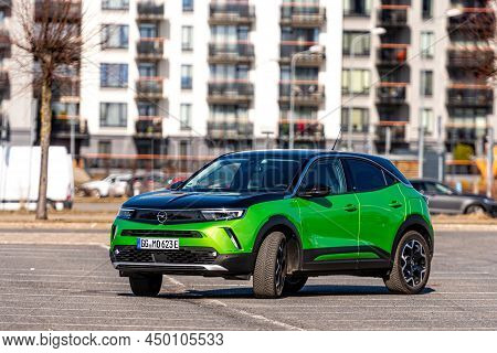 Riga, Latvia - 26 March, 2021: Green Electric Vehicle Opel Mokka-e In The Parking Lot On The Backgro