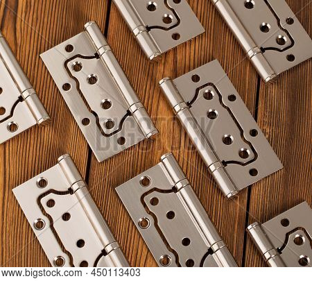 Door Metal Hinges On A Wooden Background, Macro. Door Furniture