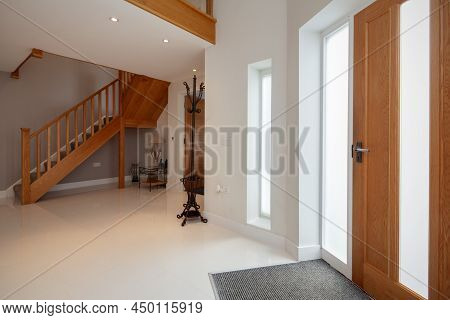 Bright Empty Home Entrance Hall With Wooden Staircase