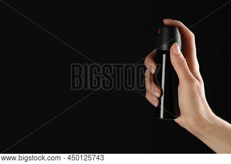 Woman Holding Pepper Spray On Black Background, Closeup. Space For Text