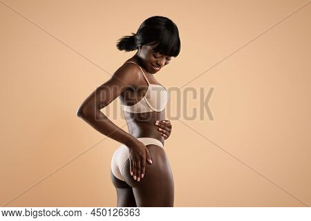 Smiling Slim African American Woman In Underwear Toucing Her Buttocks