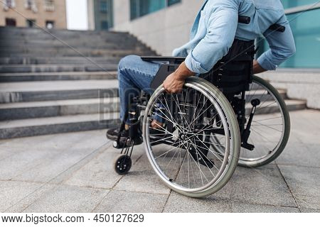 Closeup Of Young Black Man In Wheelchair In Front Of Stairs Without Ramp, Having No Possibility To E