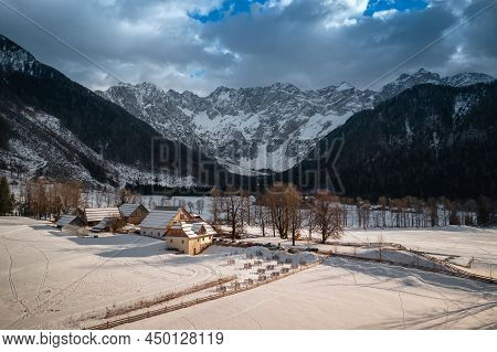 Aerial View Over Zgornje Jezersko, Slovenia In Winter With Snow. Eco Tourist Farm.