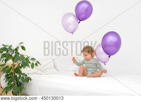 Cute Funny Caucasian Blonde Baby Girl,toddler Of 1,2 Year Old Playing On Bed With Big Purlple Balloo