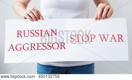 Close Up Of A Protester Hands Holding Cardboard Banner With The Words Russian Aggressor Stop War. Pr