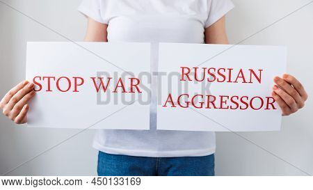 Close Up Of A Protester Hands Holding Cardboard Banner With The Words Russian Aggressor Stop War. Pr