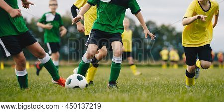 Football Summer Traing Camp For School Kids. Soccer Players Running Classic Soccer Ball On Natural G
