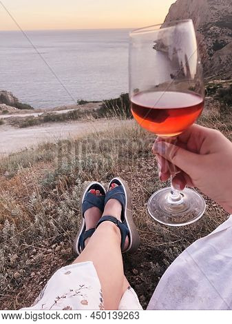 Cropped Shot Of Woman With Drinking Red Wine Enjoying Amazing Sea View And Sunset Outdoors, Relaxed 