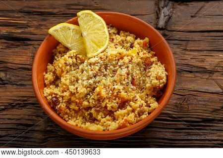 Couscous Masfouf With Dried Fruits And Nuts In A Clay Plate On A Wooden Table. Horizontal Photo