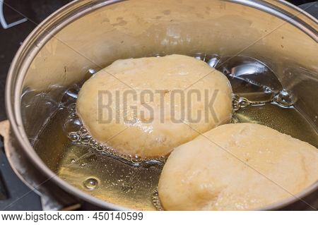 Deep Fry Polish Donuts Known As Paczki. Frying Paczek In Metal Pot.