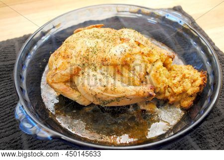A Plated Whole Roasted Game Hen In A Baking Dish