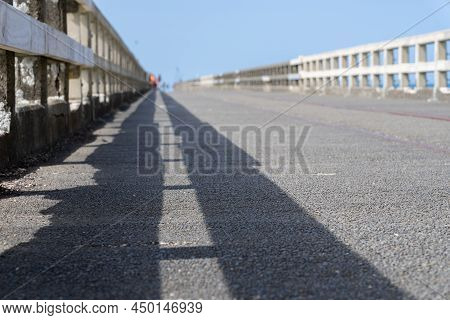 Leading Lines Of Railings And Shadows Of Long Historic Wharf, Tolaga Bay, New Zealand.