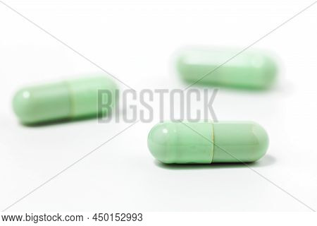 Green Chiretta Herbal Capsule On White Background With Copy Space For Healthcare And Medical Concept