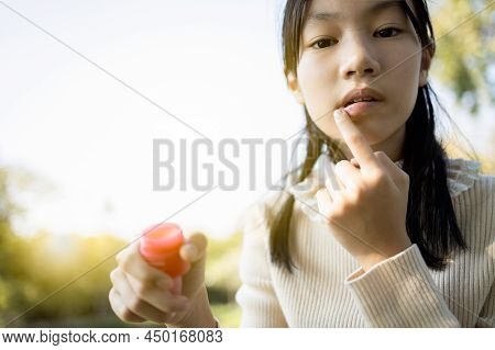 Asian Child Girl Maintains Her Lips,skin Care And Protection, Chapped Lips,dry Mouth That Have Lost 
