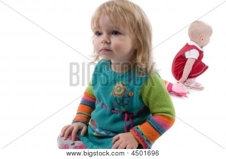 To Babyes siddende på gulvet