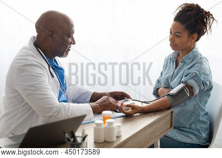 Black Doctor Checking Measuring Pressure On Pregnant Patients Hand Pulse