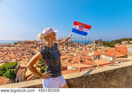 Woman With Croatian Flag On Dubrovnik Walls Of Croatia. View Of Fort Lovrijenac Fortress And Francis