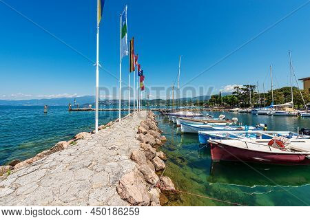 Small Port On Lake Garda With Moored Boats. Village Of Cisano, Tourist Resort On The Coast Of Lake G