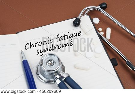 Medicine And Health Concept. On A Brown Surface Lie Pills, A Pen, A Stethoscope And A Notebook With 