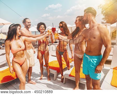 Group Of Friends With Swimsuit Drink A Cocktail In A Beach Place