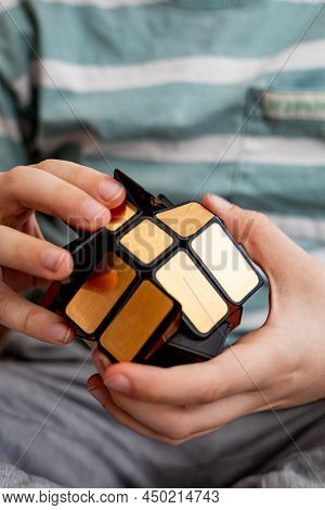 Confident Male Teenager Assembling Multicolored Rubiks Cube Mirror Mill Relaxing On Couch At Home