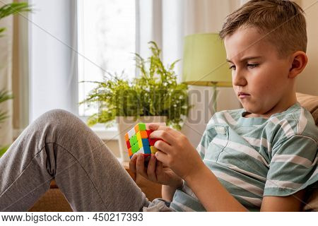 Portrait Frowning Male Teenager Brainstorming Assembling Rubiks Cube Solving Mind Logic Decision