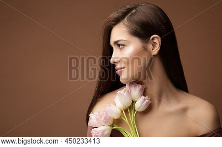 Beauty Woman With Flowers. Woman Face Portrait With Tulips Bouquet Over Beige Background. Neck Skin 
