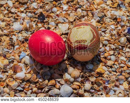 Easter Eggs On The Beach In Shells. Colorful Easter Eggs Surrounded By Seashells On The Ocean Beach.