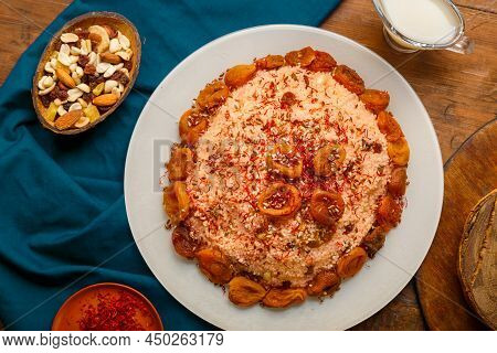 Couscous Masfouf With Dried Fruits And Nuts On A Wooden Table Next To Almond Milk And Nuts On A Blue