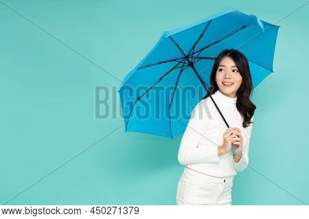 Young Asian Woman Holding Blue Umbella Standing Isolated On Green Background