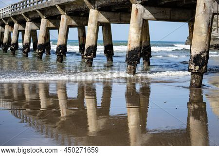 Long Repeating Structural Pattern,reflection In Wet Sand And Diminishing Perspective And Shadow Of S