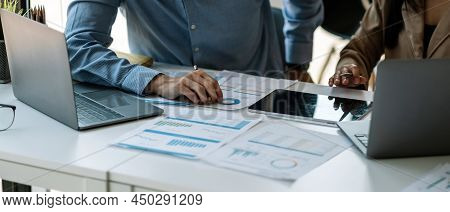 Businessman And Partnership Pointing The Graph To Analyze The Marketing Plan With Calculater And Lap