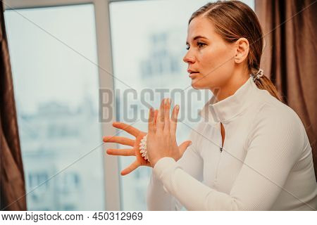 Athletic Slim Caucasian Woman Doing Thigh Self-massage With A Massage Ball Indoors. Self-isolating M