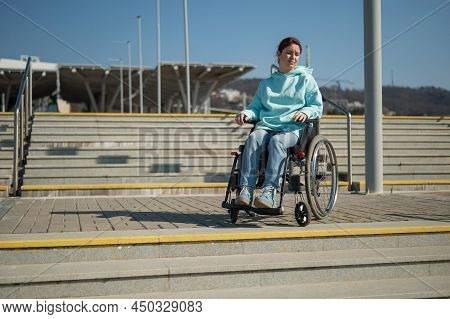 A Caucasian Woman In A Wheelchair Cannot Go Down Stairs Without A Ramp. Hard To Access Environment.