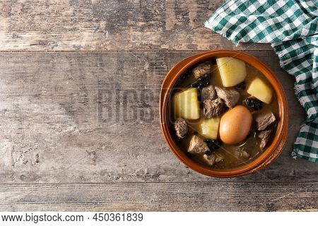 Traditional Jewish Cholent In Bowl On Wooden Table. Top View. Copy Space