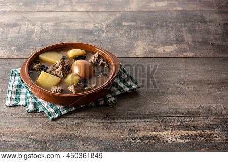 Traditional Jewish Cholent In Bowl On Wooden Table. Copy Space