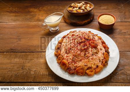 Masfouf From Couscous On Almond Milk With Dried Fruits And Nuts On A Wooden Table Next To Nuts And R