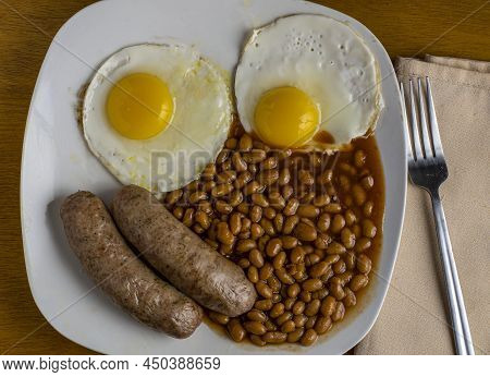 Breakfast Plate  Of Fried Eggs Sausage And Baked Beans