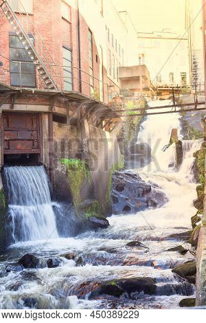 Kvarnbyn Waterfall In Old Industrial Work Area In Molndal, Gothenburg, Sweden, Sun Rays Effect, Vert