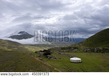 A Large And Lonely Circular Tent Or Yurt In The Middle Of A Mountain Landscape On A Cloudy Summer Da
