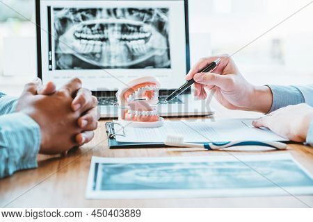 Dentist With Male Patient Presenting Discussing Dental Problems X-ray Image Film In Dental Office