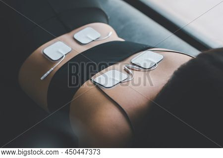 Physical Therapy For Woman Patient With Tens Electrode Pads On Back,preparing Equipment