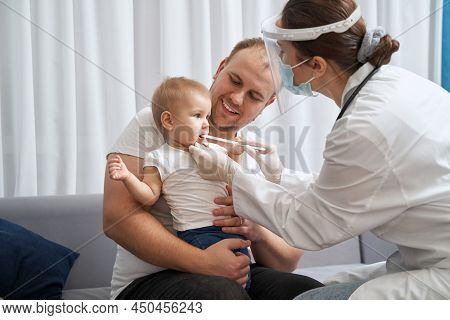 Doctor Using Tongue Depressor To Check Baby Throat
