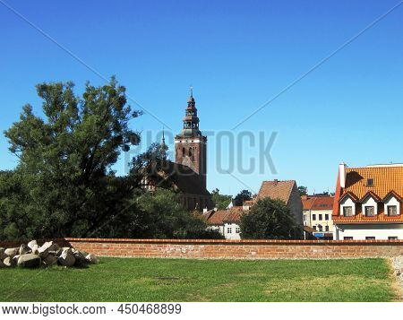 Beautiful View Of The Medieval Brick Clock Tower, Houses With Tiled Roofs In The Old Polish Town Of 