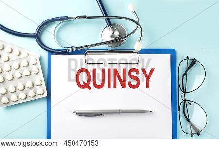 Paper With Text Quinsy On Blue Background With Stethoscope And Pills