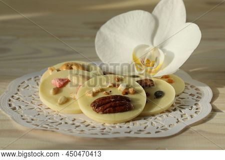 Milk Chocolate Mendiants On Wooden Table With Orchid