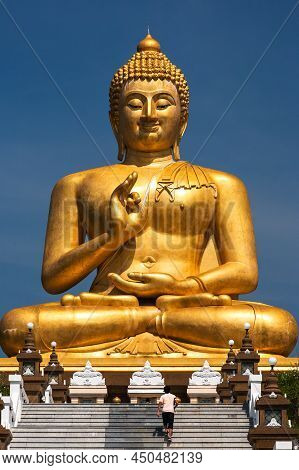Tourists Visiting The Giant Bronze Buddha Image With Karana Mudra Hand Position In Narathiwat, South