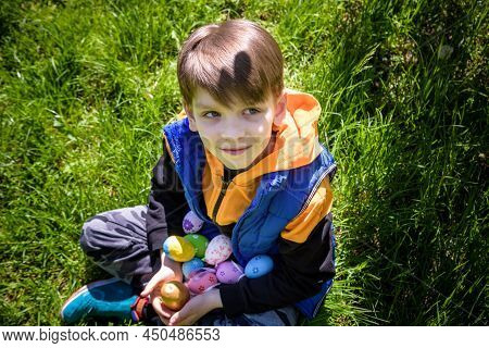 Different Color Easter Eggs In A Child's Hands After Egg Hunt. Traditional Easter Concept. Happy Boy